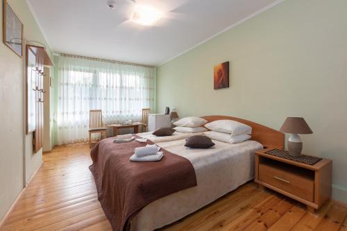 a bedroom with a large bed with towels on it at Valensija in Jūrmala