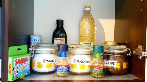 a shelf with jars of condiments and bottles at GUEST HOLIDAY GRAMSCI in Reggio Emilia