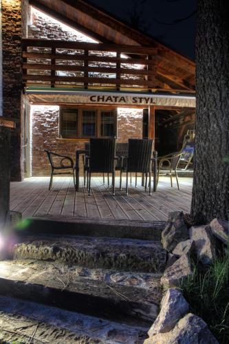 a wooden deck with chairs and a table on it at Chata Styl in Hlinsko