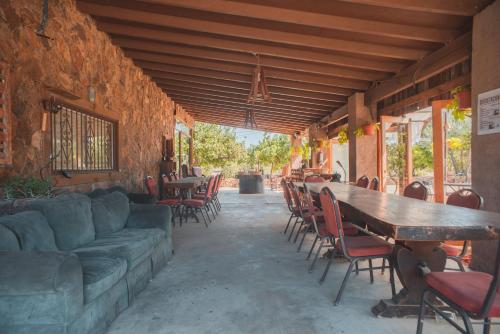 a living room with a couch and tables and chairs at Hotel Castillo Ferrer in Valle de Guadalupe