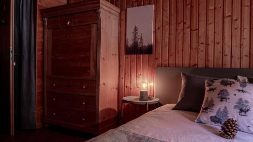 a bedroom with a bed and a dresser with a candle at Relais des Mélèzes in Vissoie