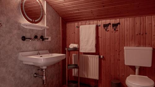 ein Bad mit einem Waschbecken und einem WC in der Unterkunft Relais des Mélèzes in Vissoie