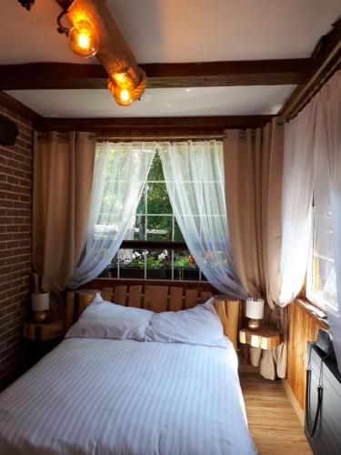 una camera con un grande letto e una finestra di Pokój SERCE KRYNICY a Krynica Morska