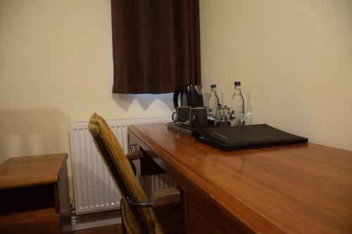 a wooden desk with a coffee maker and bottles on it at The Bell and Bottle in Maidenhead