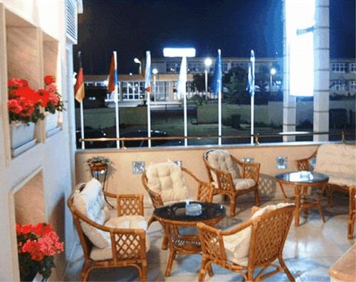 a patio with chairs and tables and a window at Filippos in Nea Moudania