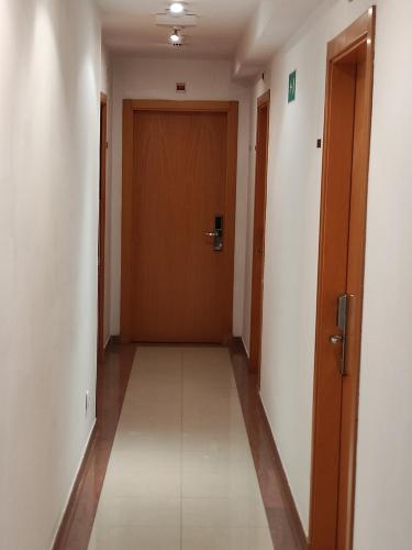 a hallway with a wooden door and a hallwayngth at Nap Carta Puebla in Oviedo