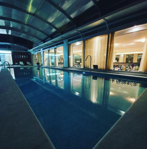 a large swimming pool in a building at night at Monte Gordo Hotel Apartamentos & Spa in Monte Gordo