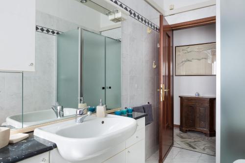 een badkamer met een witte wastafel en een bad bij Parma A due passi dall'Ospedale Apartment in Parma