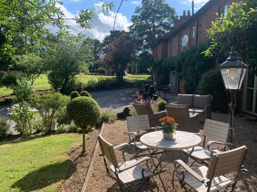 a patio with chairs and a table in a yard at Scarborough Hill Country Inn in North Walsham