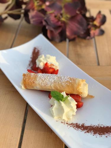 a white plate with food on a wooden table at Strandhotel Schmerikon in Schmerikon