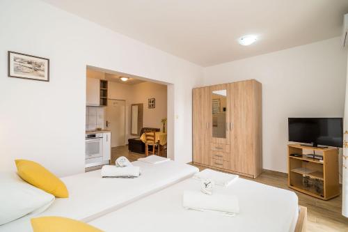 a living room with two white couches and a television at Guest House Nenada in Dubrovnik