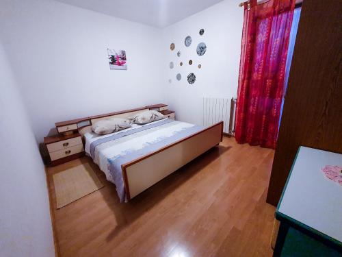 a bedroom with a bed and a wooden floor at Apartment Licardo in Sveti Lovreč Pazenatički