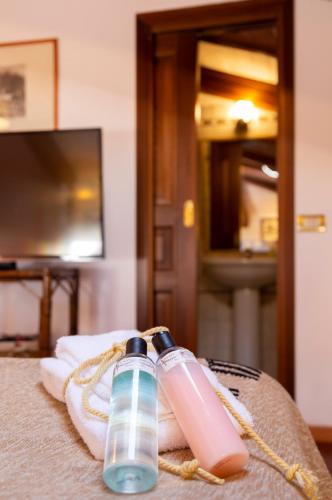 two water bottles sitting on top of a bed at Palazzo Sismonda in Corneliano d'Alba