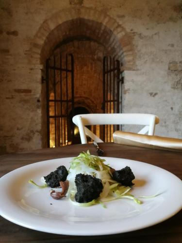 a white plate with broccoli on a table at Villa Anitori Prestige Relais & Spa in Loro Piceno