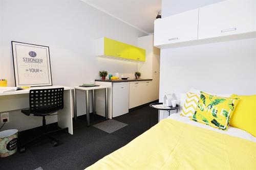 a room with a bed and a desk and a kitchen at Salsa Hostel Premium in Łódź
