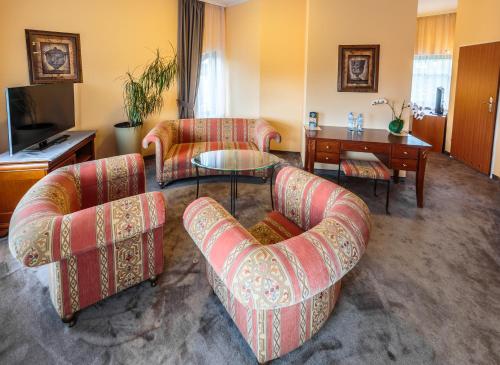 a living room with two chairs and a table at Hotel Fenix in Jelenia Góra