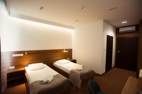 a hotel room with two beds and a mirror at Hotel Rubin in Stara Blotnica