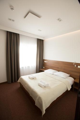 a bedroom with a large bed with two towels on it at Hotel Rubin in Stara Blotnica