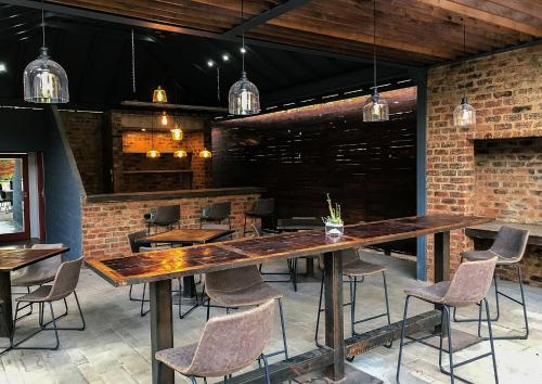 a dining room with a large wooden table and chairs at The Doors Inn in Mokopane