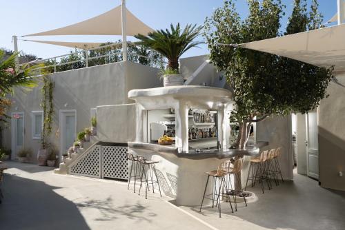 a bar on the side of a building with stools at Edem Boutique Suites in Oia