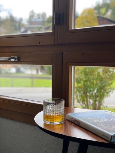 a glass sitting on a table next to a window at Luxury family apartment Engelberg in Engelberg