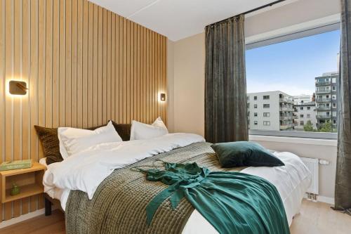 1 dormitorio con 1 cama grande y ventana grande en BJØRVIKA APARTMENTS, Teaterplassen, Oslo city center, en Oslo