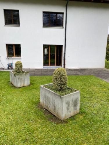 two concrete planters in the grass in front of a building at Luxury family apartment Engelberg in Engelberg