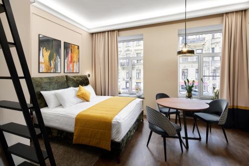 a hotel room with a bed and a table and chairs at Kaleidoscope GOLD in Saint Petersburg