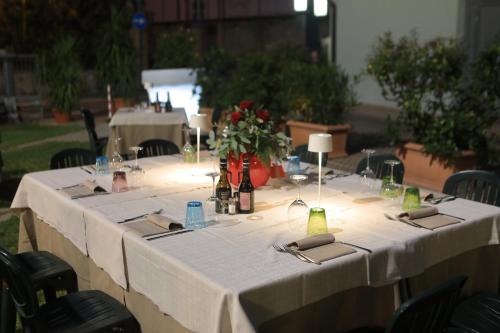 a long table with a white table cloth and flowers at Hotel Eden in Valeggio sul Mincio
