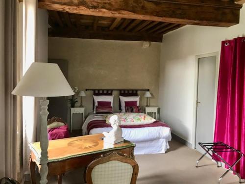 a bedroom with two beds and a table with a lamp at Côté-Serein suites familiales du Clos in Noyers
