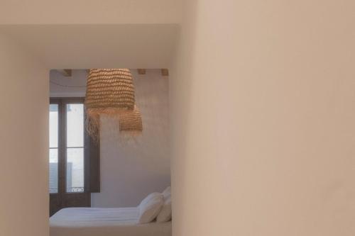 a bedroom with a bed and a chandelier at Can Araya in Ciutadella