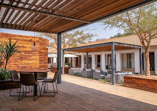 an outdoor patio with a table and chairs at The Doors Inn in Mokopane