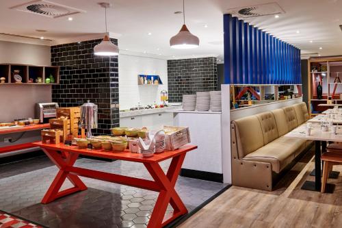 a restaurant with a table with food on it at Holiday Inn Leeds Garforth, an IHG Hotel in Garforth