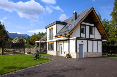 a white house with a gambrel roof at Śnieżka Exclusive Apartamenty in Kowary