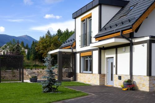 a white house with a black roof at Śnieżka Exclusive Apartamenty in Kowary