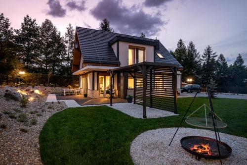 a house with a fire pit in the yard at Śnieżka Exclusive Apartamenty in Kowary