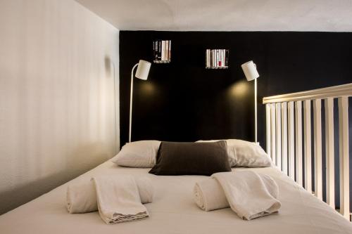 Una cama con mantas blancas y almohadas. en So Sweet Capitole en Toulouse