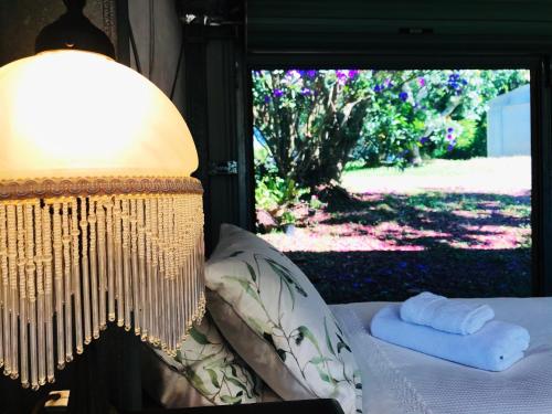 sypialnia z łóżkiem, lampką i oknem w obiekcie Maleny Monet Studio w mieście Maleny