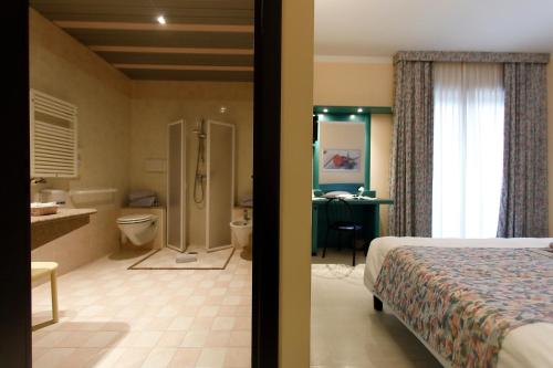 ヴァレッジョ・スル・ミンチョにあるHotel Edenのベッドとバスルーム付きのホテルルームです。