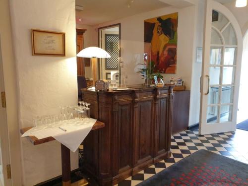 a restaurant with a counter with wine glasses on it at Hotel Altes Pfarrhaus Beaumarais in Saarlouis