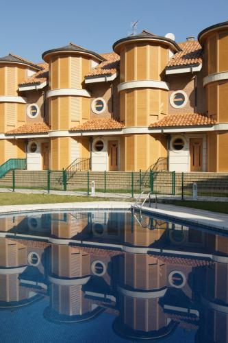 a building with a pool in front of it at Apartamentos Quinto Sueño in Noja
