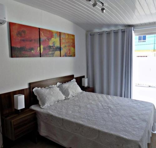 a bedroom with a bed and a window at Sorrento Suítes Maragogi a 3 min da Orla in Maragogi