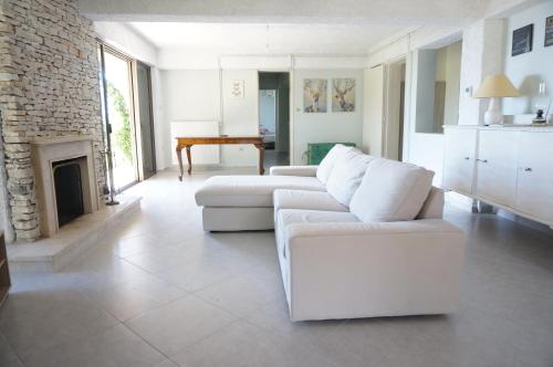 a living room with a white couch and a fireplace at Kefalonia Sea View Cottage in Áno Váltai