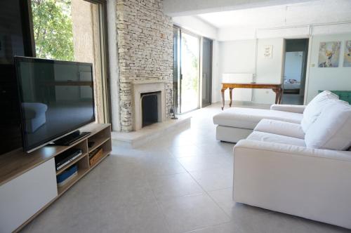 a living room with a white couch and a television at Kefalonia Sea View Cottage in Áno Váltai