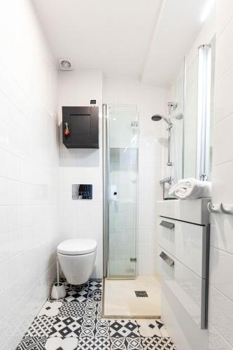 une salle de bain avec toilettes et douche en verre dans l'établissement Veeve - Elegant Interiors in Bastille, à Paris