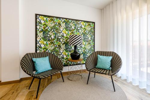 two chairs and a lamp in a room with a painting at Quinta da Pontinha in Alenquer