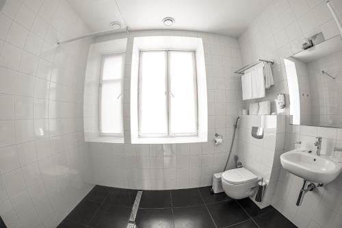a white bathroom with a sink and a toilet at Kolobok in Luts'k