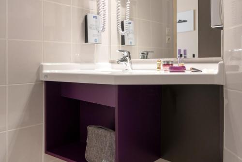 a bathroom with a white sink and a mirror at Kyriad Hotel Lyon Givors in Givors