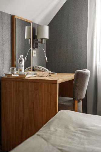 a wooden desk with a chair next to a bed at Kolobok in Luts'k