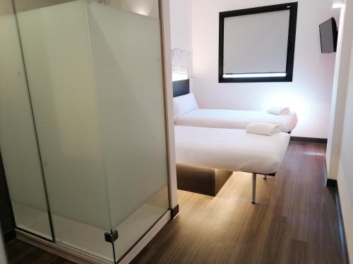 a hotel room with a bed and a mirror at easyHotel Malaga City Centre in Málaga